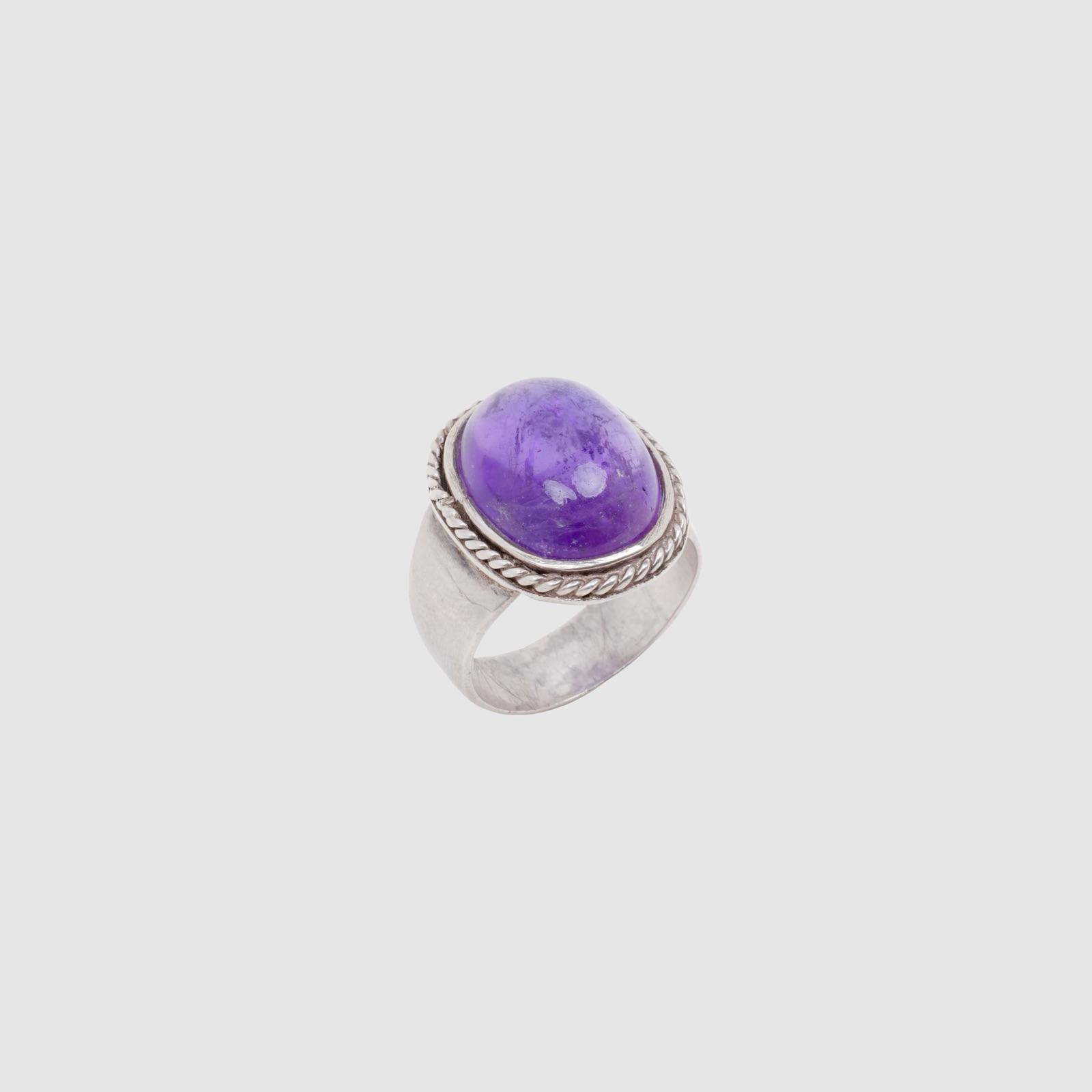 A silver ring set with a large domed purple amethyst.