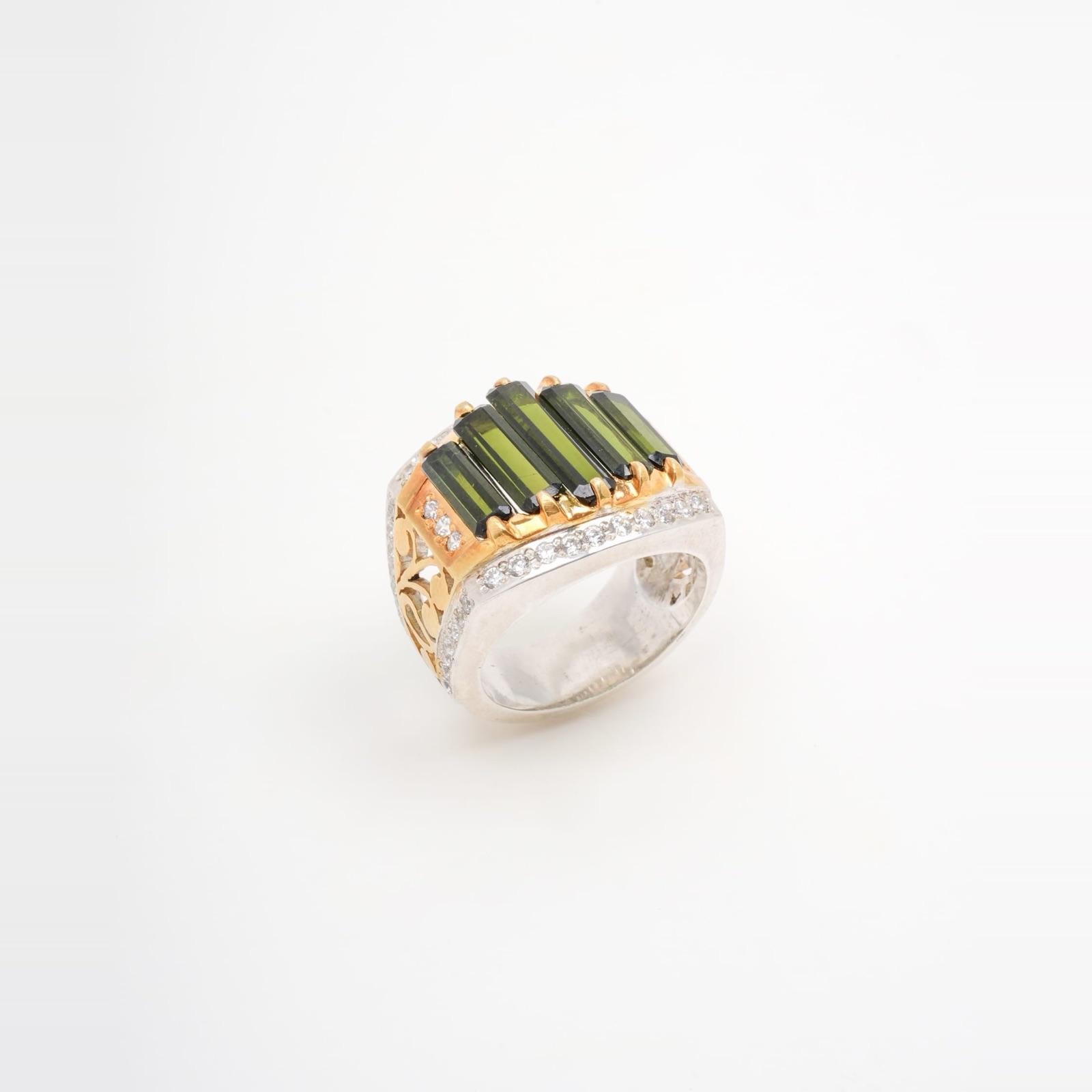 A wide silver ring with gold accents, set with five rectangular green stones.