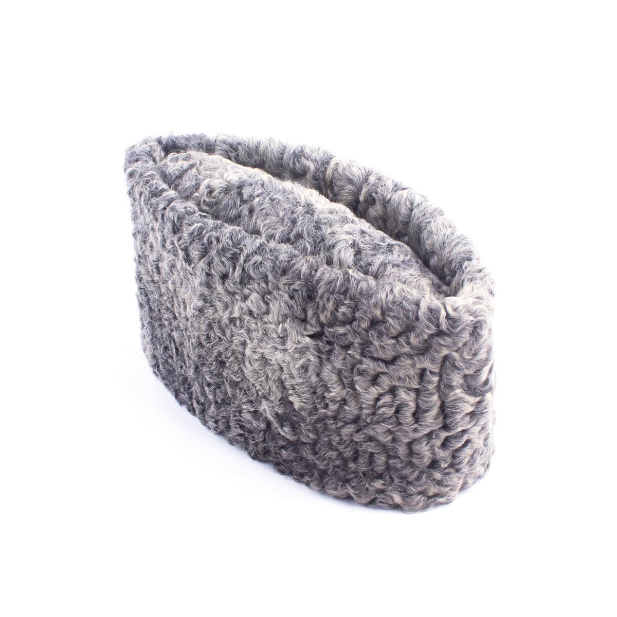 A folded grey hat made of curled karakul wool.