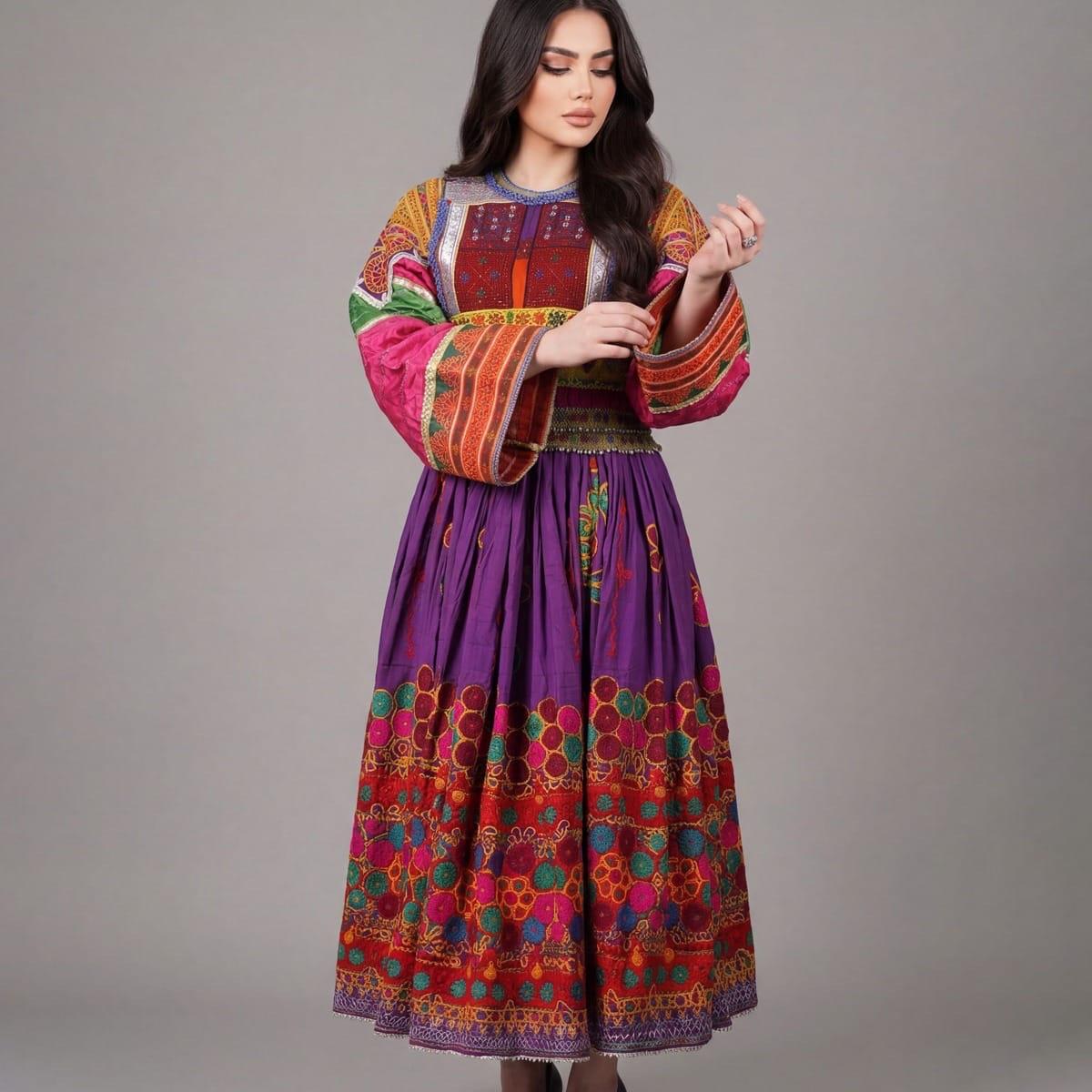 A woman in a long purple dress with colourful patchwork sleeves and a heavily embroidered skirt hem.