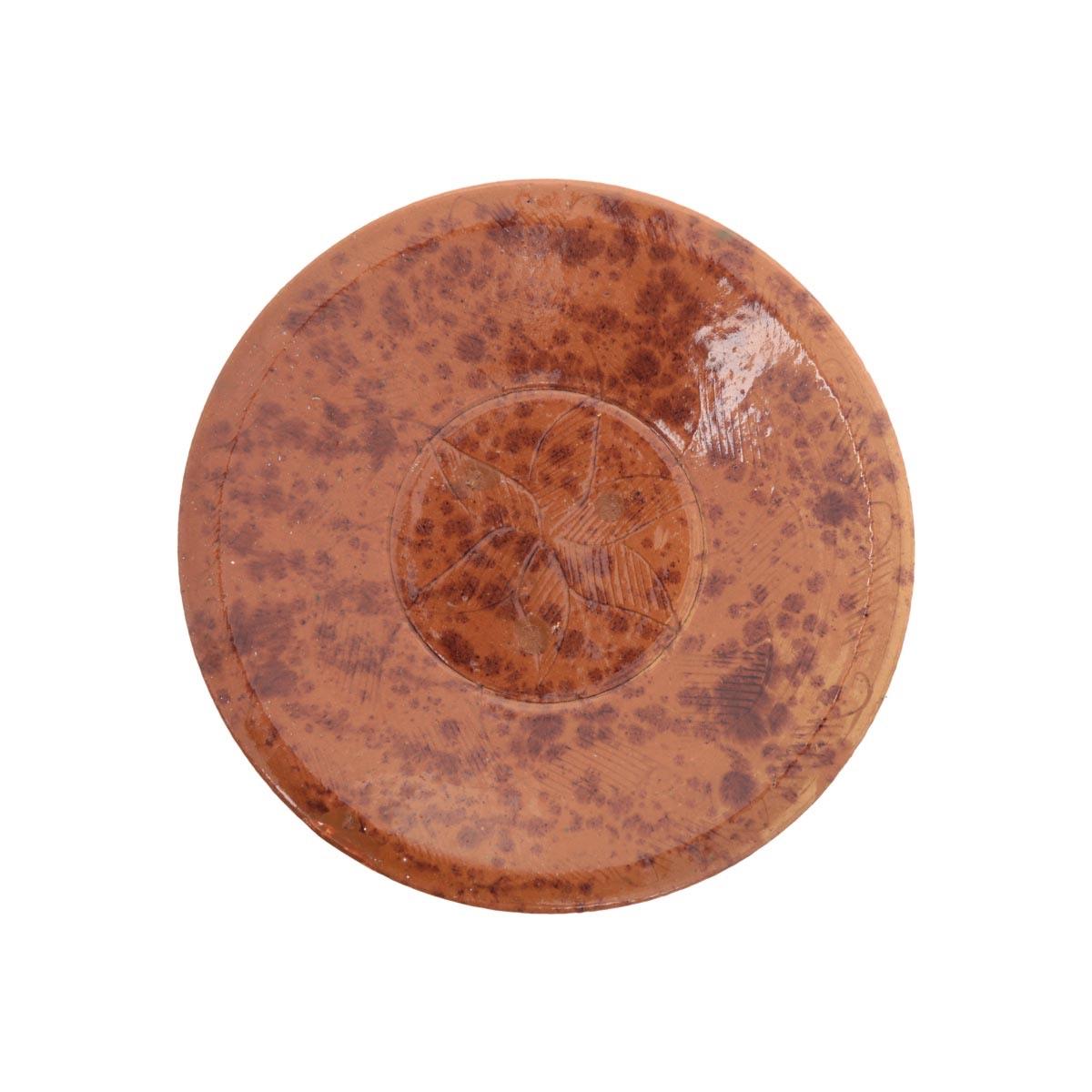 A round ceramic plate in a speckled amber-brown glaze.