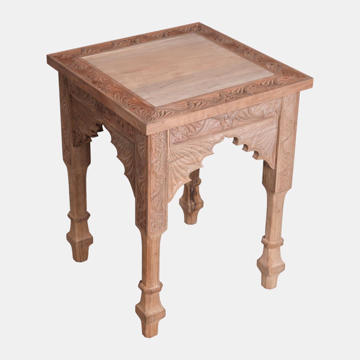 A square carved wooden side table with arched sides and turned legs.